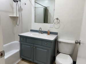 Bathroom with vanity, toilet, and shower / tub combo with curtain