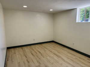 Empty room with wood finished floors, baseboards, and recessed lighting