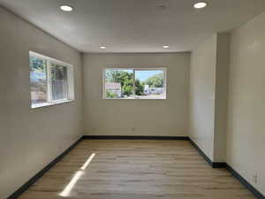Unfurnished room featuring light wood-style floors, recessed lighting, and baseboards