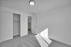 Unfurnished bedroom with carpet flooring, baseboards, and a closet