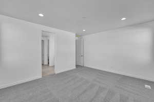 Spare room featuring carpet flooring, recessed lighting, and baseboards