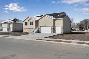 View of front of property featuring a garage, stucco siding, and driveway
