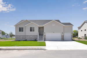 Ranch-style home featuring stone siding, driveway, a front yard, and stucco siding