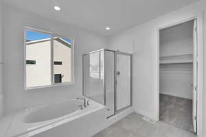 Full bath with a garden tub, a shower stall, a walk in closet, recessed lighting, and tile patterned flooring