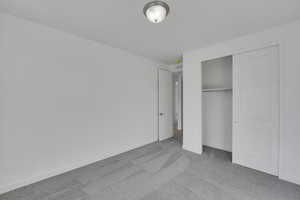 Unfurnished bedroom featuring carpet, a closet, and baseboards