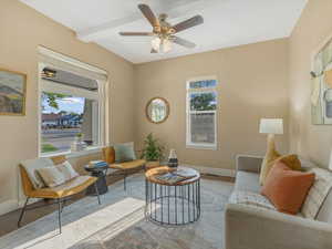 Living room with baseboards, wood finished floors, ceiling fan, and beamed ceiling