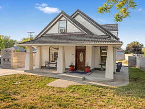 View of front of house with a porch, cooling unit, and brick siding