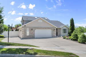 View of front of home featuring an attached garage, concrete driveway, and brick siding