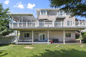 Rear view of house with a deck, french doors, and stucco siding