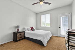 Bedroom featuring access to outside, light colored carpet, baseboards, and ceiling fan