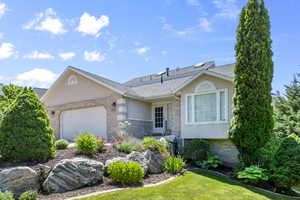 Single story home with stucco siding, a garage, a shingled roof, and brick siding