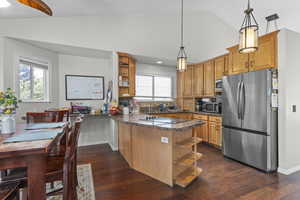 Kitchen featuring appliances with stainless steel finishes, open shelves, a peninsula, dark wood-style floors, and high vaulted ceiling