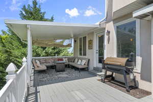 Wooden deck with an outdoor hangout area and area for grilling
