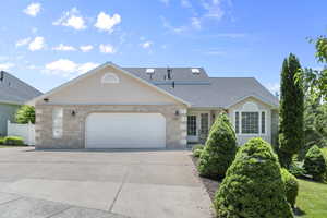 View of front of home featuring driveway, a garage, brick siding, and roof with shingles