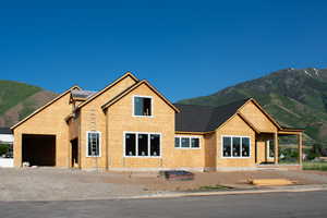 Property in mid-construction with an attached garage and a mountain view