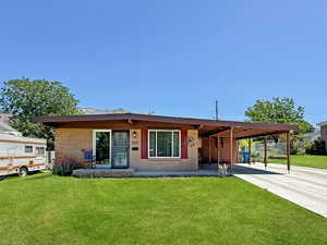 View of front facade featuring a carport and concrete driveway