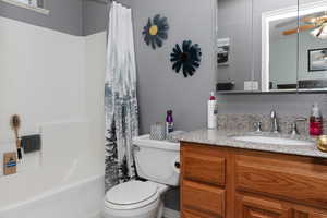Full bath featuring vanity, toilet, and shower / tub combo with curtain
