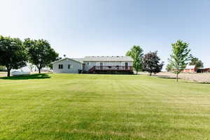 View of green lawn with a wooden deck