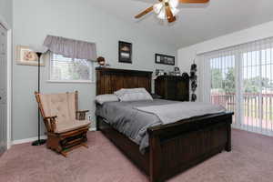 Bedroom with light colored carpet, lofted ceiling, access to exterior, a ceiling fan, and baseboards