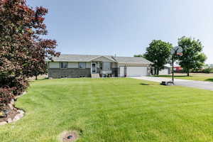 Single story home with concrete driveway, a garage, and a front yard