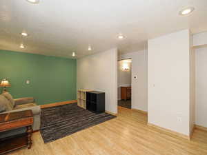 Living area with light wood-type flooring, baseboards, and recessed lighting
