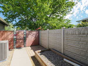 View of patio with central AC unit and a gate