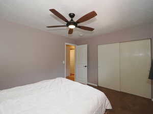 Bedroom featuring carpet floors, a ceiling fan, and a closet