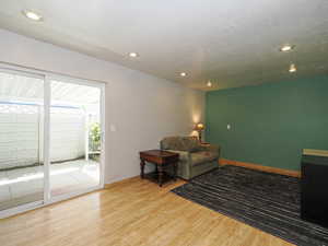 Living area with wood finished floors, recessed lighting, and baseboards