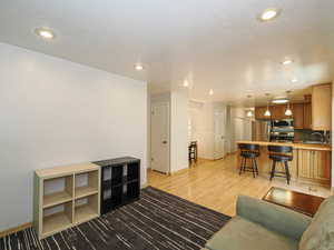 Living area featuring baseboards, recessed lighting, and light wood-style flooring