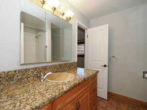 Bathroom with vanity, baseboards, and a shower