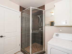 Bathroom with washer / clothes dryer and a shower stall