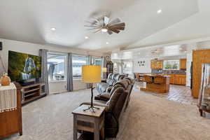 Living area featuring light colored carpet, a ceiling fan, recessed lighting, and vaulted ceiling
