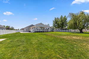 Rear view of property featuring a wooden deck and a patio