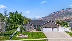 View of front facade featuring an attached garage, concrete driveway, a gate, and a mountain view
