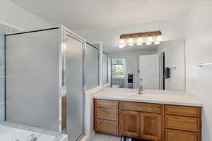 Bathroom featuring vanity, a stall shower, and a bath