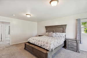 Bedroom with light carpet and baseboards