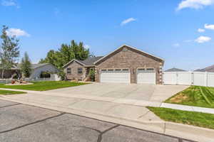 Single story home featuring a gate, driveway, a garage, and brick siding