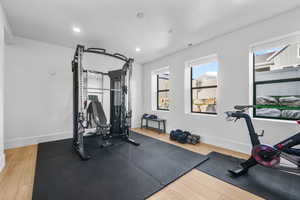 Exercise room featuring baseboards, wood finished floors, and recessed lighting
