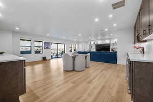 Living area featuring light wood finished floors, recessed lighting, and baseboards