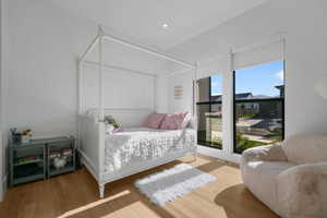 Bedroom with multiple windows, wood finished floors, and recessed lighting