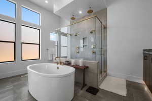 Full bath with a stall shower, tile patterned floors, a freestanding bath, baseboards, and vanity
