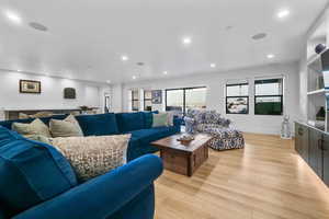 Living room with light wood finished floors and recessed lighting