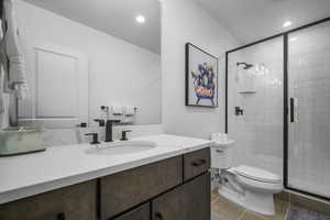 Full bathroom with vanity, toilet, a stall shower, tile patterned floors, and recessed lighting