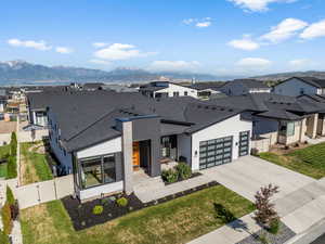 Contemporary home with a gate, a residential view, concrete driveway, and a shingled roof
