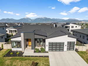 Contemporary home with a gate, an attached garage, a residential view, and driveway