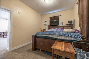 Bedroom featuring carpet flooring and baseboards