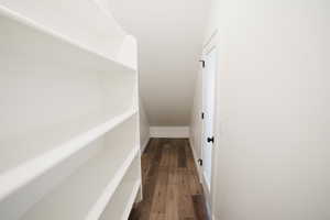 Hallway featuring dark wood finished floors and baseboards
