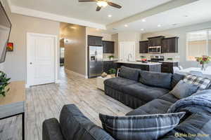 Living room featuring ceiling fan, recessed lighting, light wood-style flooring, and baseboards