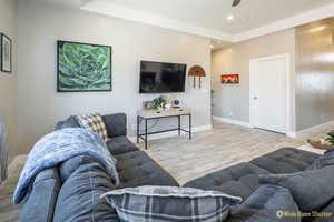 Living area featuring wood finished floors, baseboards, ceiling fan, and recessed lighting