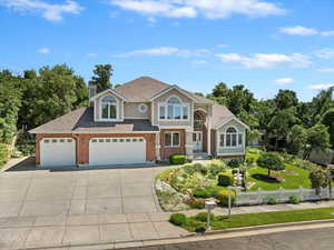 View of front of house with driveway, brick siding, roof with shingles, a chimney, and a garage